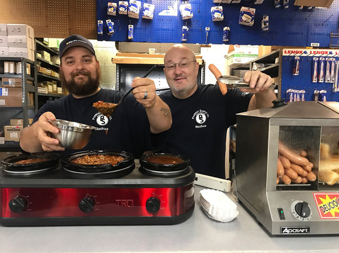 Peabody Plumbing Supply Nashua NH hot dog day - Counter team offering hot dogs